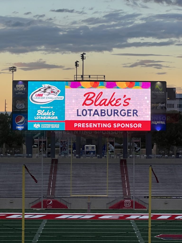Blake's Lotaburger logo on an electronic billboard over a grand stand