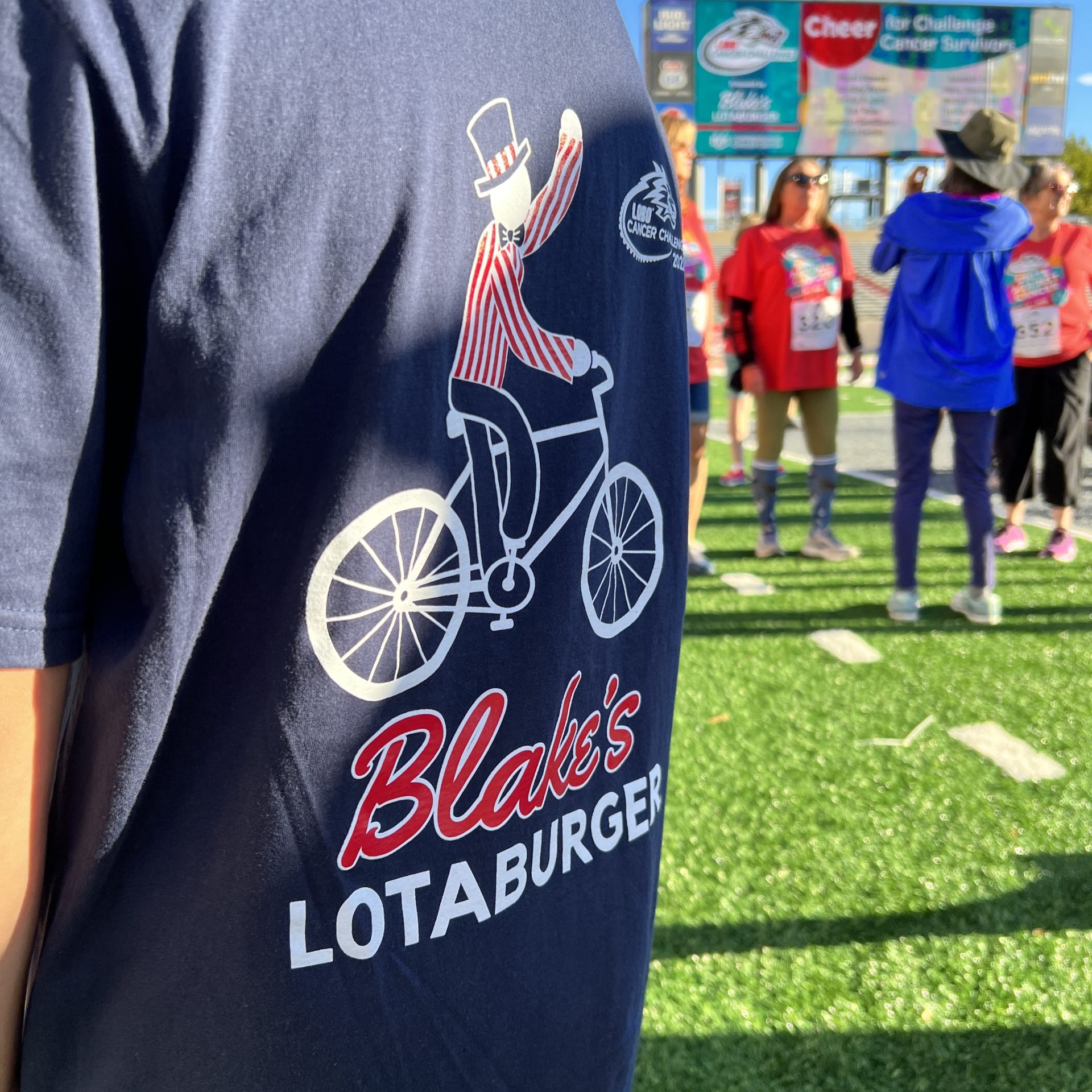 backside of a Blake's Lotaburger t-shirt with team in the background