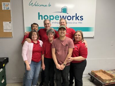 Blakes team getting a group photo in front of a Hopeworks sign