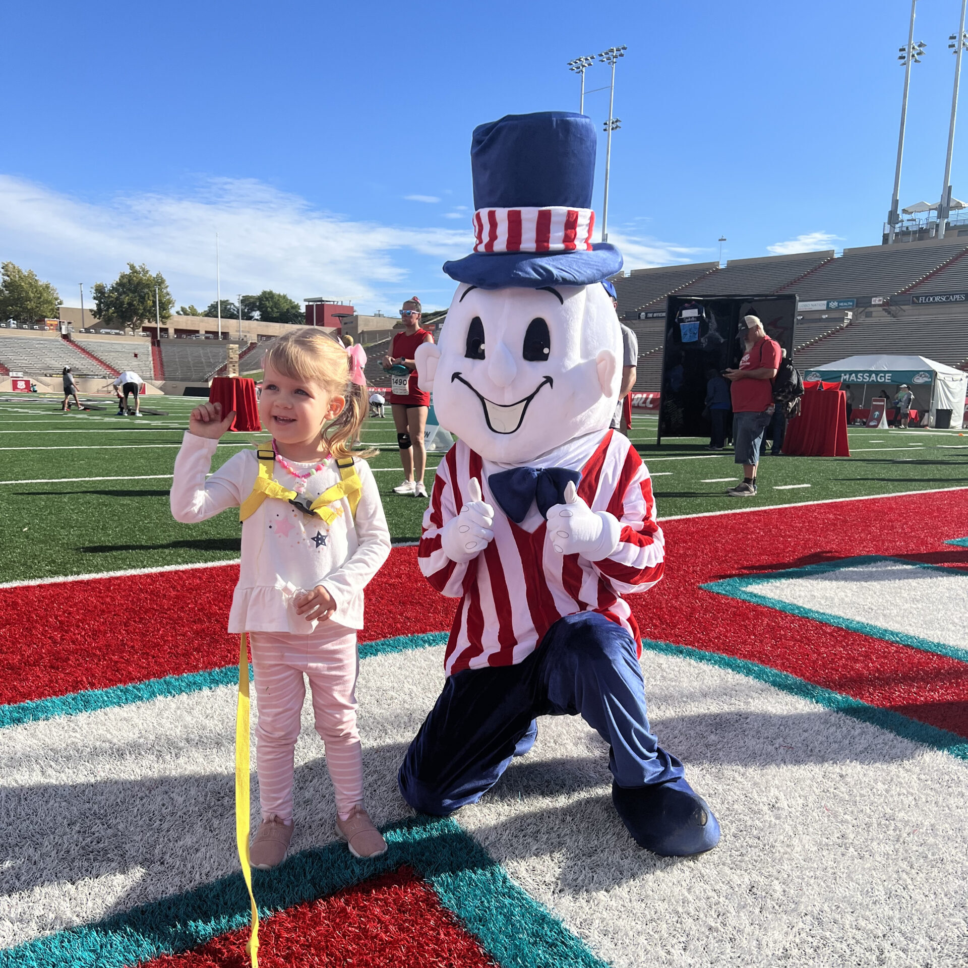A little girl getting her picture taken with Blake's Mascot