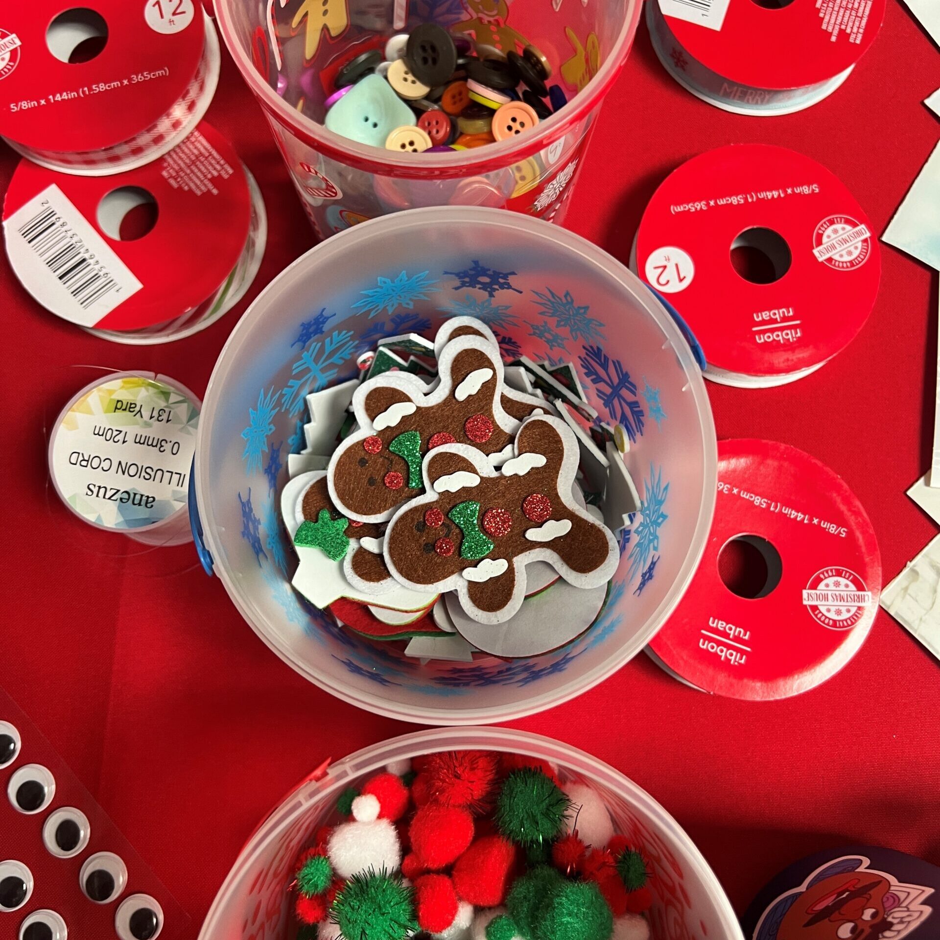 Photo of holiday decorations, gingerbread men, ribbons, Christmas colored puff balls, and googley eyes