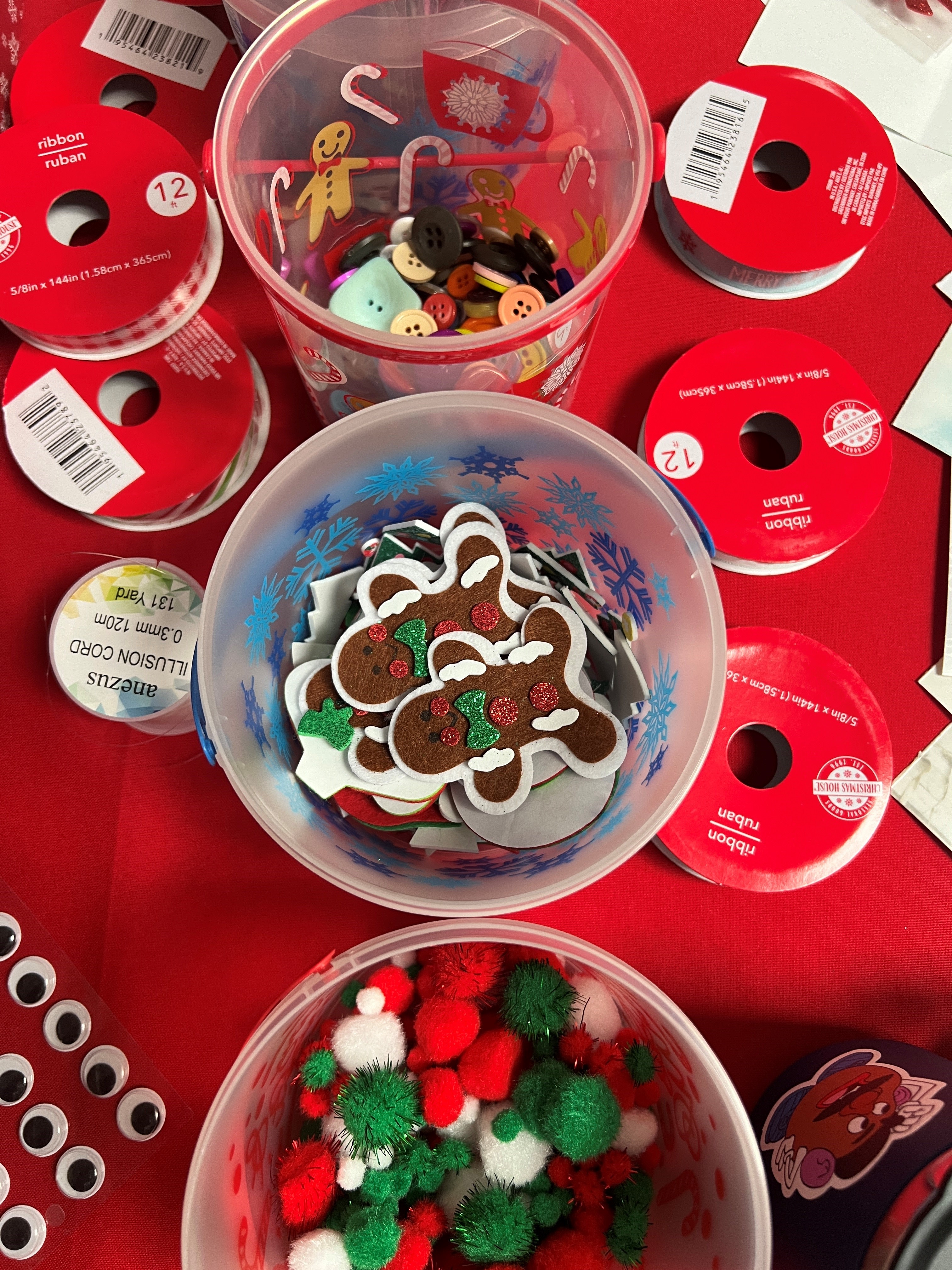 Photo of holiday decorations, gingerbread men, ribbons, Christmas colored puff balls, and googley eyes