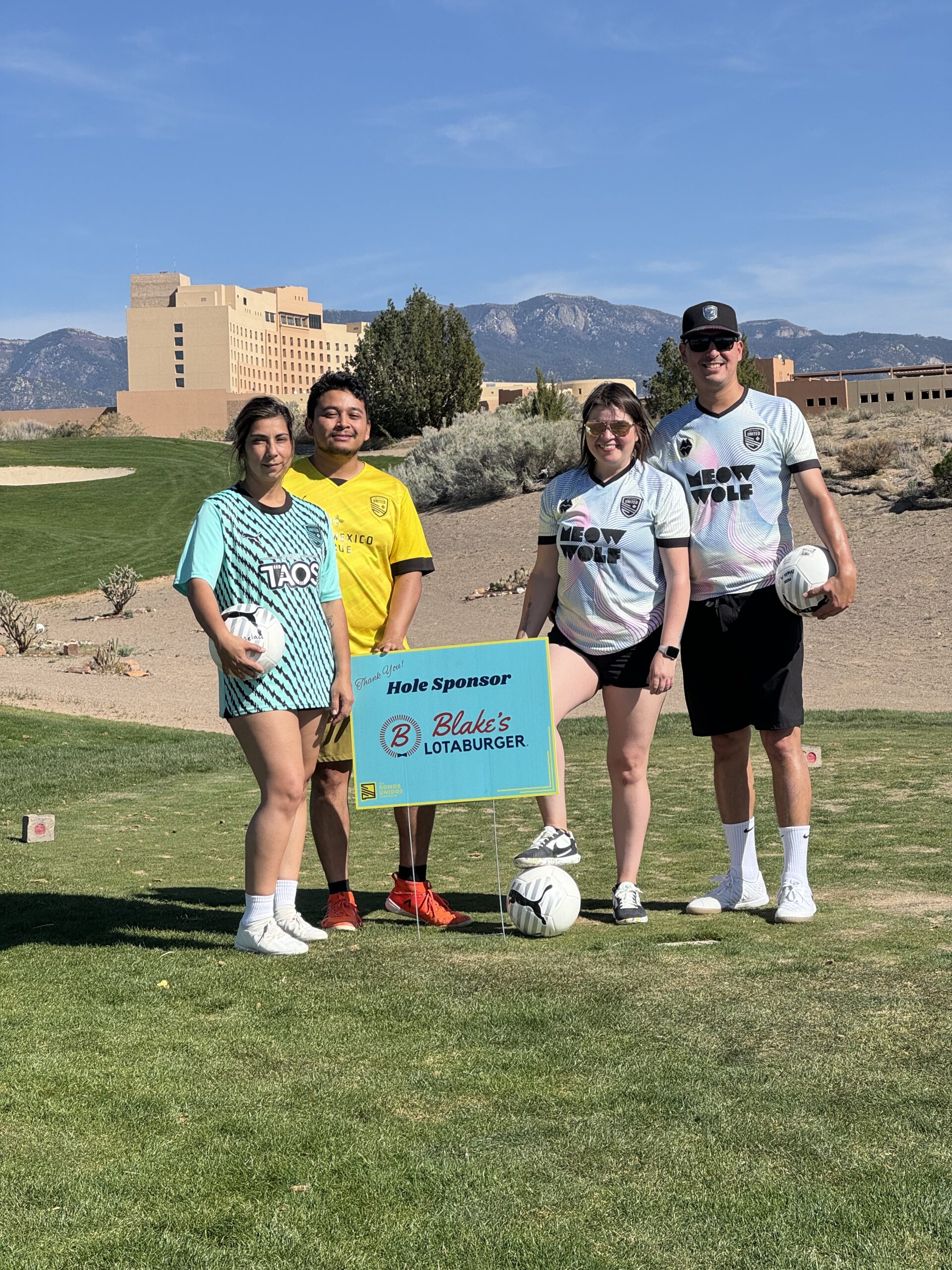 Blake's HR team standing in front of a sponsorship sign
