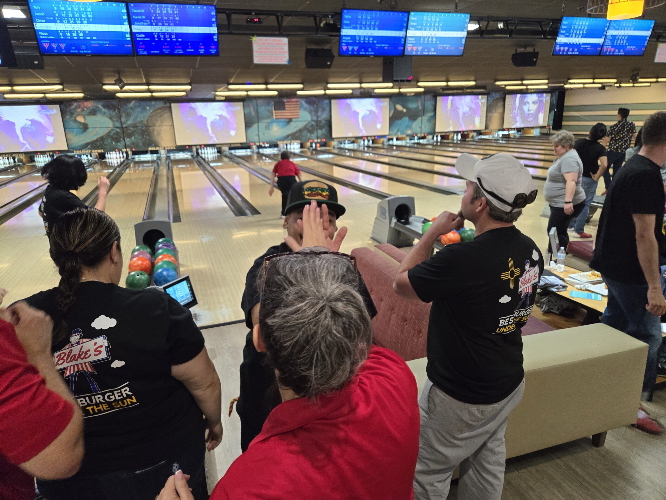 Event attendees watching team members bowl.