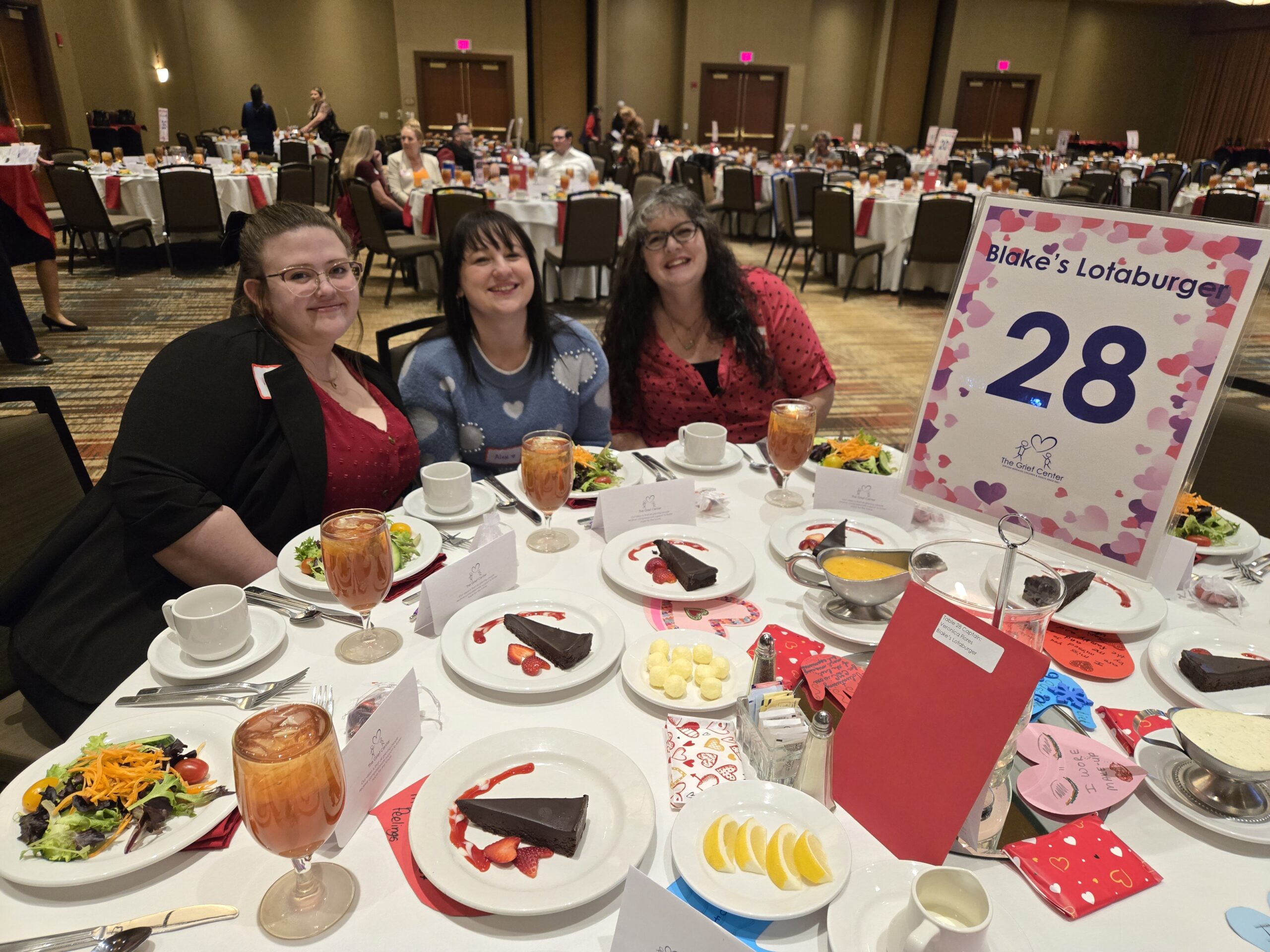 Three Blake’s Lotaburger employees sitting at a dinner banquet table
