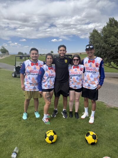 Blake's team members in soccer jerseys with yellow soccer balls in front