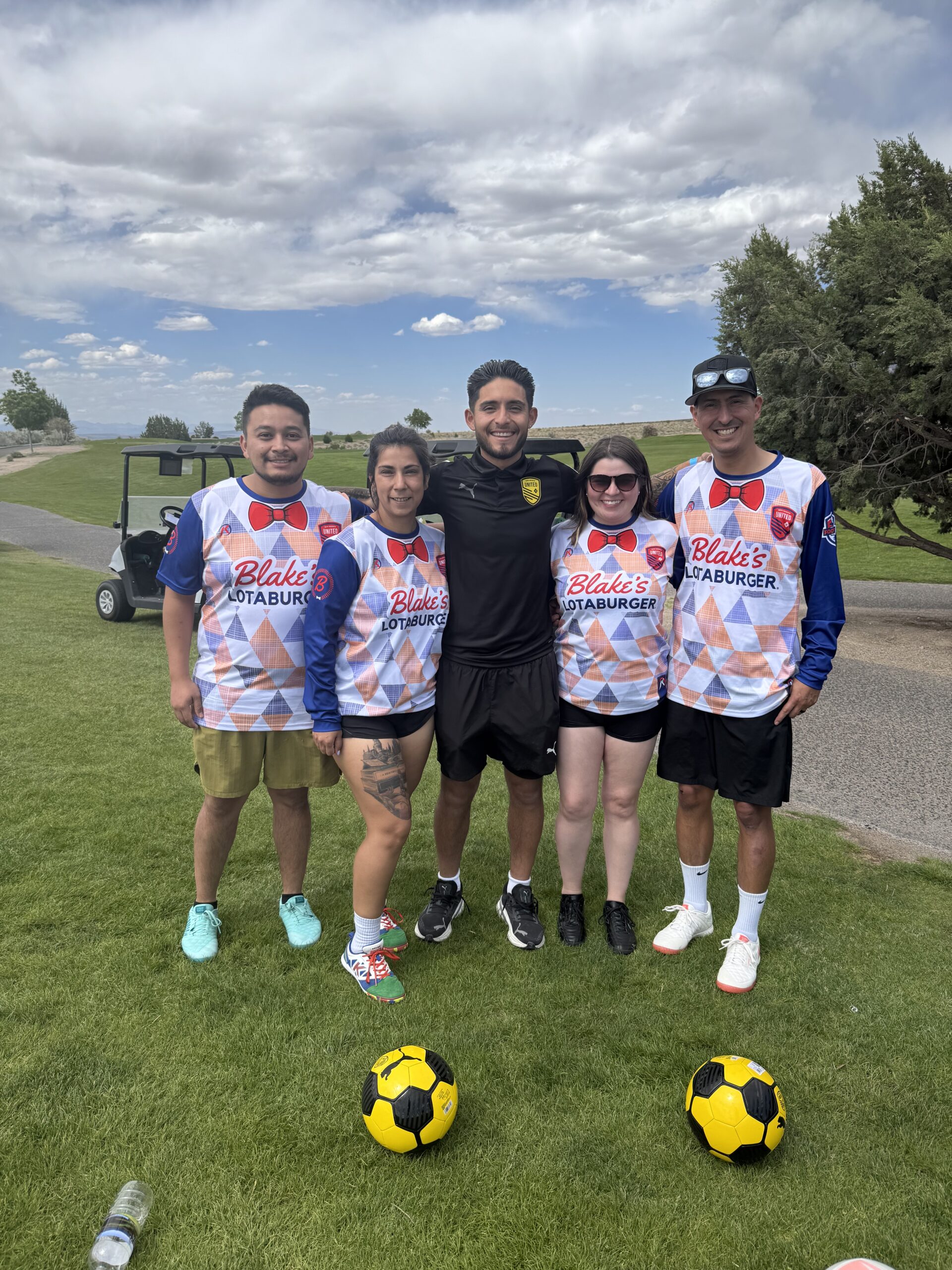 Blake's team members in soccer jerseys with yellow soccer balls in front