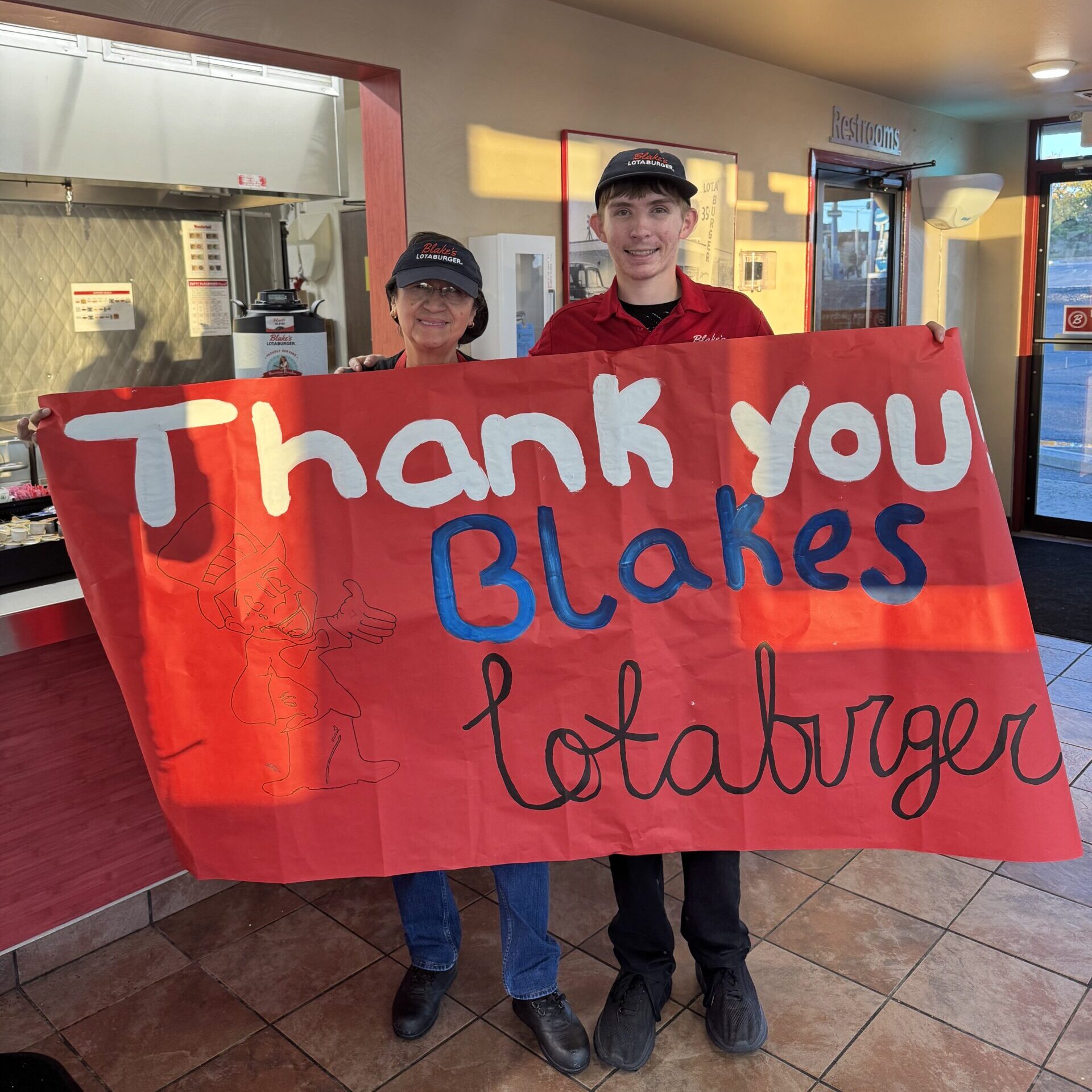 Blake's team members holding a sign saying Thank you Blakes Lotaburger