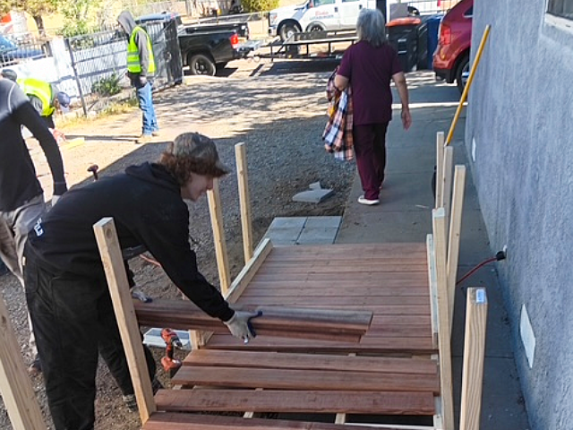 Member of Blake's team member in black hat putting together a wheelchair ramp
