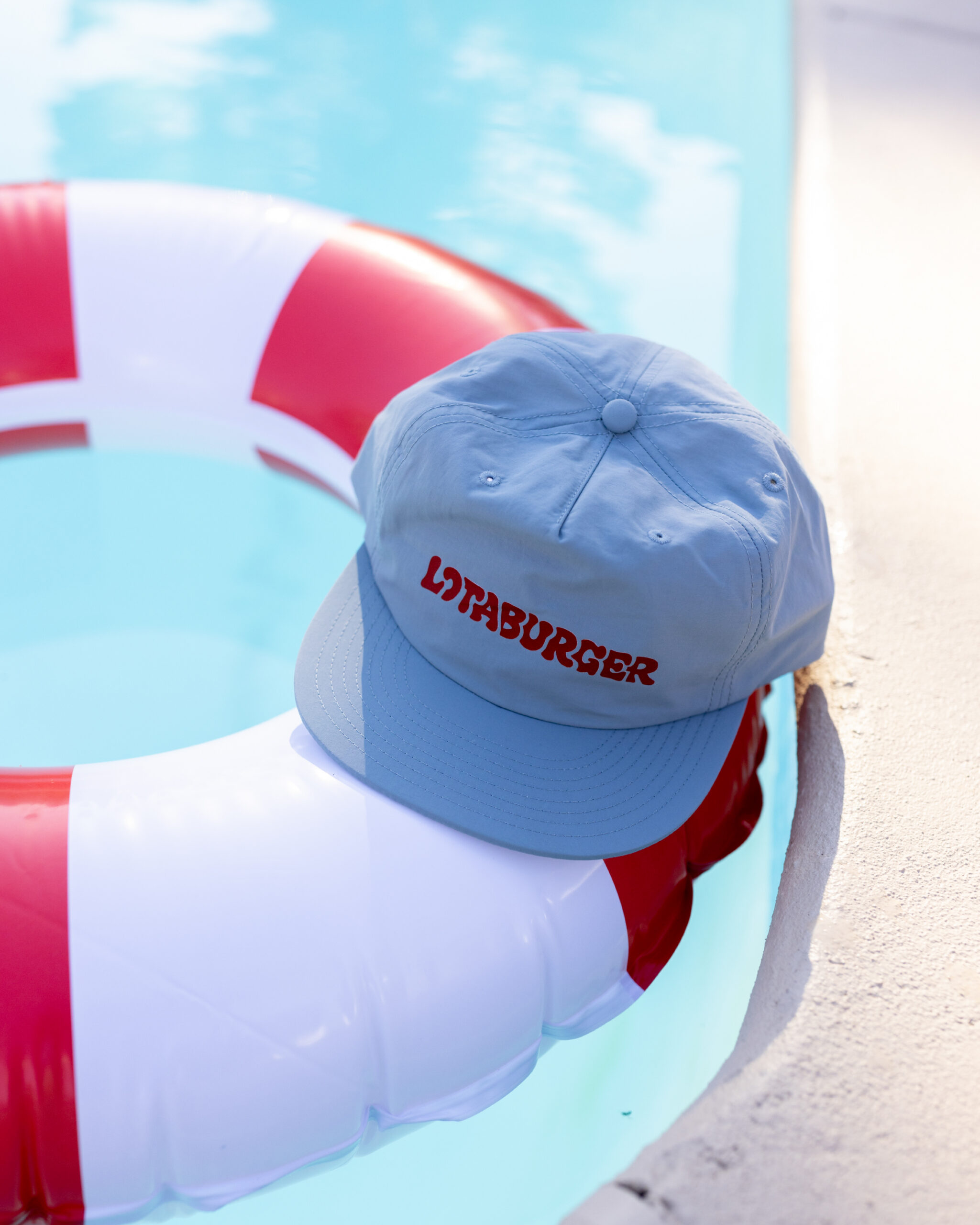 a gray hat with LOTABURGER in red on it